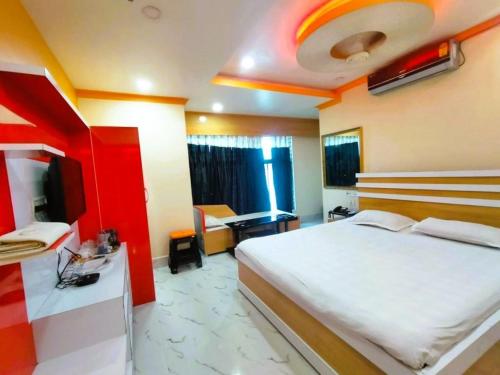 a bedroom with a large bed and a red and white room at Hotel Anurag Palace In Agartala in Agartala