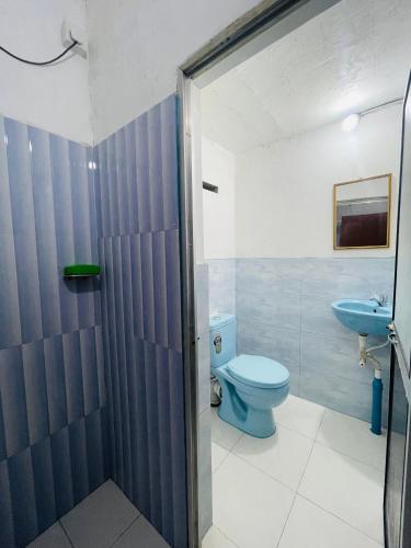 a bathroom with a blue toilet and a sink at Chaaya Cottage in Bentota