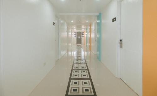 a hallway with white walls and a long line of floors at Sans Hotel near Enchanted Kingdom Santa Rosa Laguna in Santa Rosa