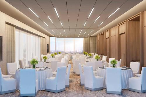 a room with white tables and white chairs at JW Marriott Hotel Guadalajara in Guadalajara