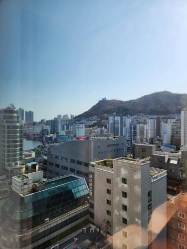 a view of a city with buildings and a mountain at Brand New Residence with Family in Busan