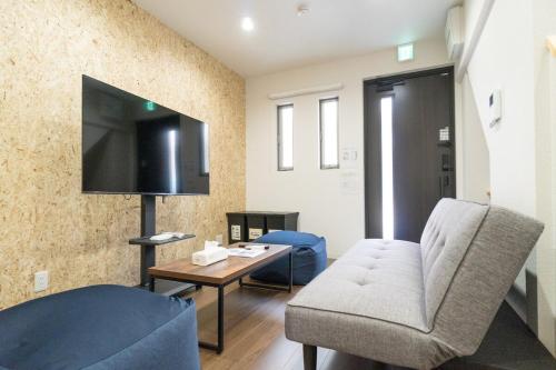 a living room with a couch and a tv at Laina Kyobashi2 in Osaka