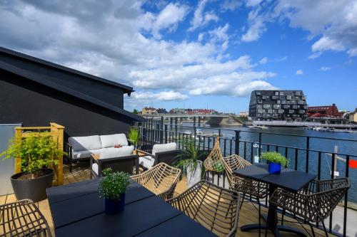a balcony with chairs and tables on a building at Blomlöfs Hotell Saltö in Karlskrona