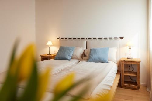 a bedroom with a white bed with blue pillows at CasaMartini Bed & Breakfast in Fonte