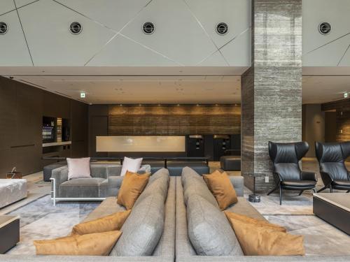 a living room with a couch and chairs at HOTEL FORZA SAPPORO STATION in Sapporo