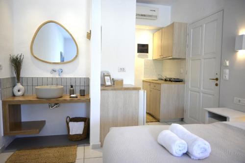 W łazience znajduje się łóżko, umywalka i lustro. w obiekcie Marika Studios & Apartments w mieście Georgioupolis