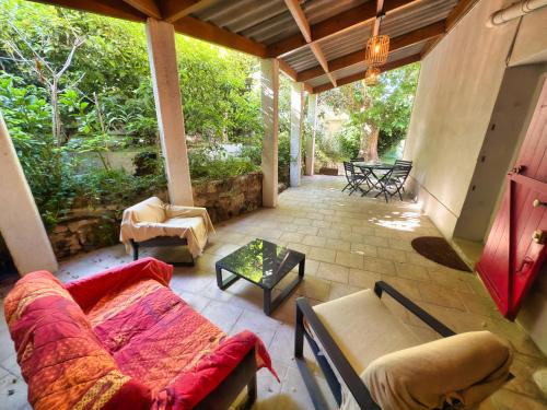 une véranda avec un canapé et une table dans l'établissement Maison de Charme Classée 3 étoiles - Calme, Jardin, Salle de Sport, Piscine, à Marseille
