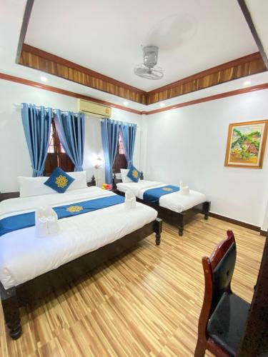 Postel nebo postele na pokoji v ubytování Luangprabang Singharat Place 2