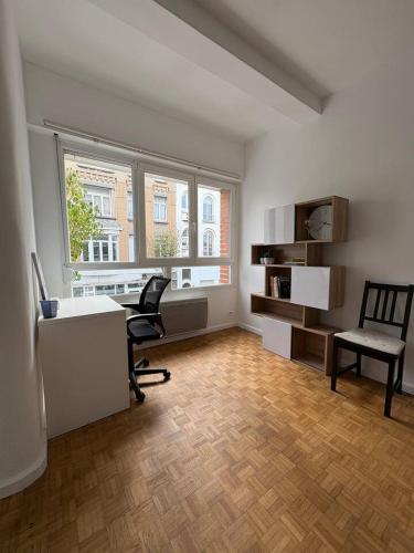 un bureau avec un bureau, une chaise et une fenêtre dans l'établissement L'appart du Parc Malo, à Dunkerque