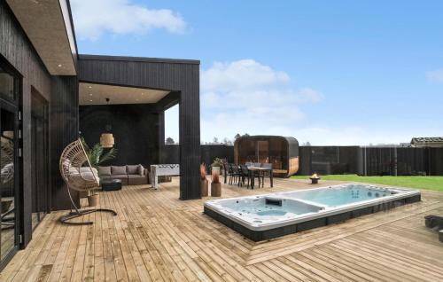 a patio with a hot tub on a wooden deck at Awesome Home In Odder With Sauna in Odder