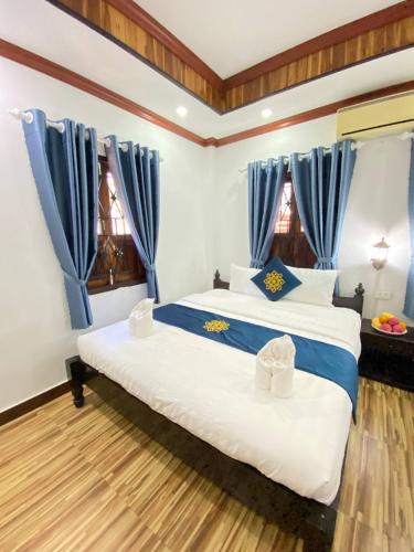 Postel nebo postele na pokoji v ubytování Luangprabang Singharat Place 2