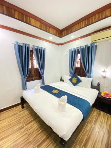 Postel nebo postele na pokoji v ubytování Luangprabang Singharat Place 2