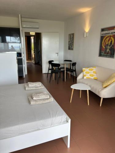 un salon avec un canapé et une table dans l'établissement Grand studio rte des sanguinaires Superbe vue Mer, à Ajaccio