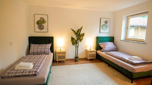a room with two beds and a window at Papyrer Apartment - Stilvolles Apartment in Lenggries in Lenggries