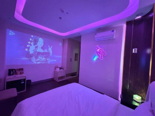 a bedroom with a purple room with a bed and a projector at Star Night Hotel and Apartment in Hanoi