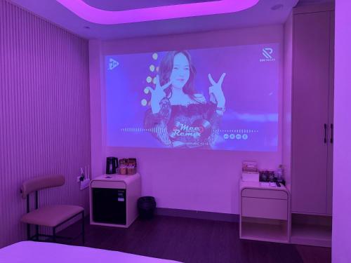 a purple room with a screen with a girl on it at Star Night Hotel and Apartment in Hanoi