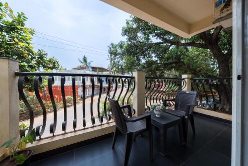 a balcony with two chairs and a table at Helloworld Riverbank Inn in Morjim