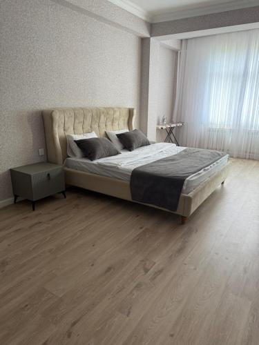 a bedroom with a large bed with a large window at Mart's 3 room apartment in Sumqayyt