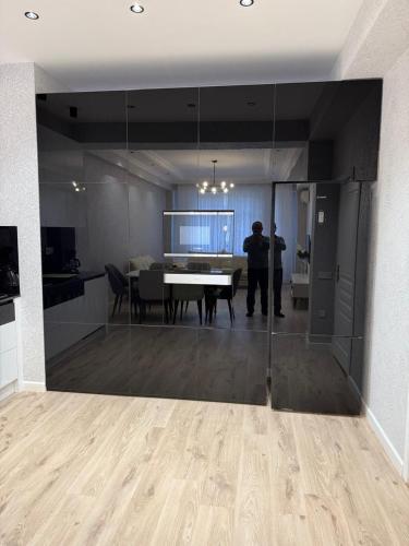 a man standing in a living room with a table at Mart's 3 room apartment in Sumqayyt
