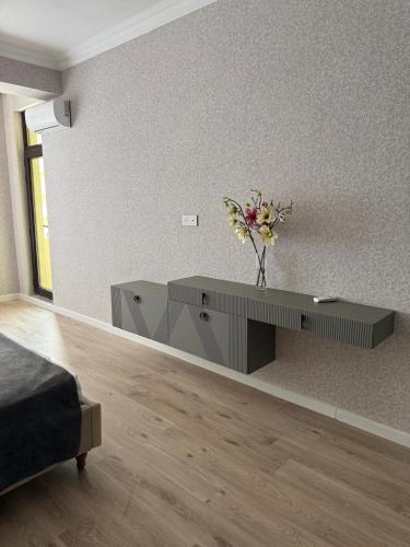 a living room with a table with a vase of flowers at Mart's 3 room apartment in Sumqayyt