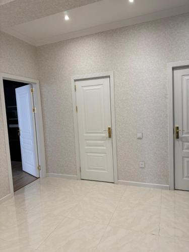 an empty room with two doors and a tile floor at Mart's 3 room apartment in Sumqayyt