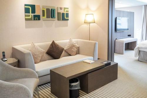 a living room with a couch and a table at 塔木德酒店 台中火車站館 Talmud Hotel Taichung Station in Taichung