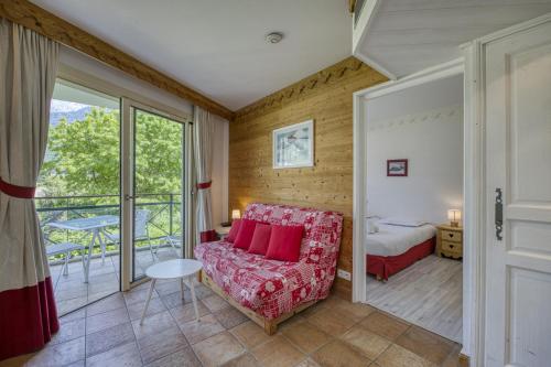 デュアンにあるRoseaux du Lacのソファとベッドと窓のある部屋