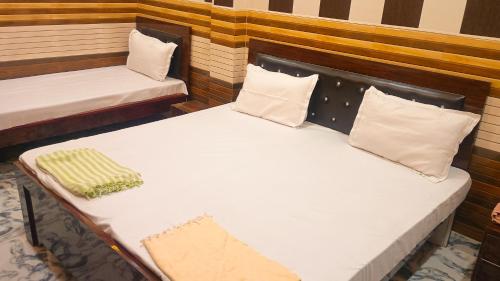 a pair of beds in a room with pillows at vaidehi homlee premium stay, 3kms from Shri Ram janmbhoomi, Ayodhya in Faizābād