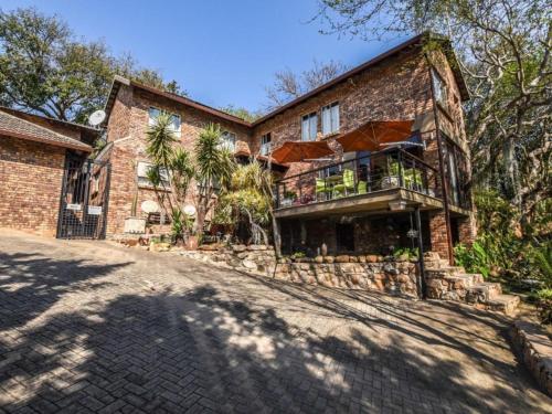 una casa in mattoni con balcone sul vialetto di Willow Inn a Nelspruit