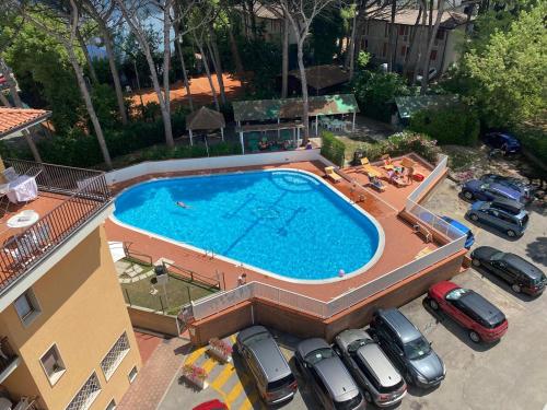 an overhead view of a large swimming pool in a parking lot at I Pini Apartment in Eraclea Mare
