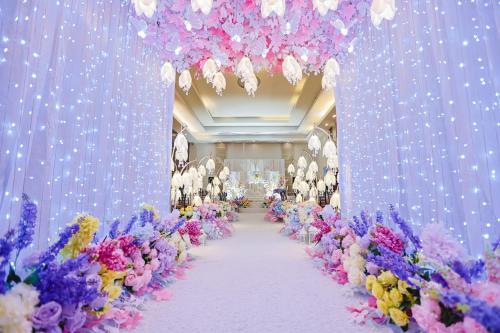a corridor with purple and pink flowers and lights at Holiday Suites Puerto Princesa in Puerto Princesa City