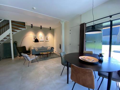 a dining room and living room with a table and chairs at Landgoed Nuwenhuys in Breda