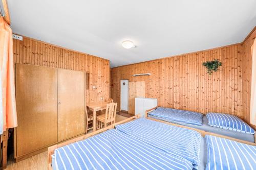 a bedroom with a bed and a wooden wall at Ubytování u Foltýnů - Hracholusky in Pňovany