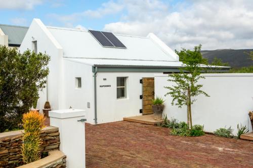 a white house with solar panels on the roof at The Blomhuis Apartments in McGregor