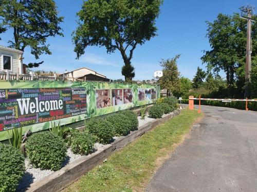 une clôture avec des affiches dessus à côté d'une route dans l'établissement CAMPING VILLAGE PUYROND Bressuire, à La Celle-sous-Gouzon