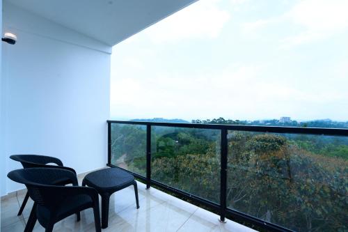 a room with chairs and a balcony with a view at Velvet Clouds Munnar in Munnar