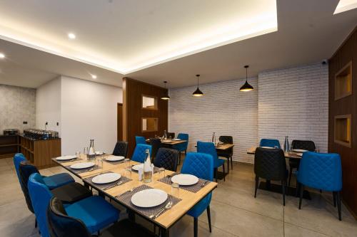 a restaurant with wooden tables and blue chairs at Velvet Clouds Munnar in Munnar
