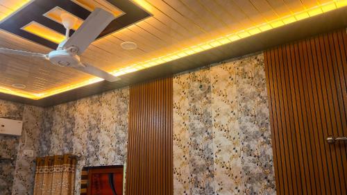 a ceiling fan in a room with a wall at vaidehi homlee premium stay, 3kms from Shri Ram janmbhoomi, Ayodhya in Faizābād