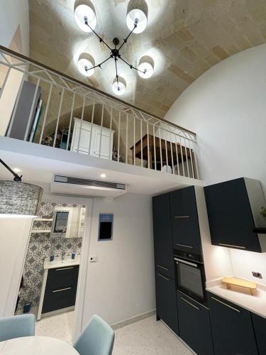a kitchen with black and white cabinets and a staircase at Casa di nonna Pina in Manduria