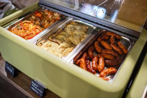 a buffet of food with sausages and other foods at R73 Residences in Pécs