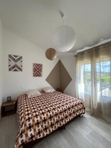 - une chambre avec un grand lit et deux lampes suspendues dans l'établissement Les maisons de Lina, à Les Mées