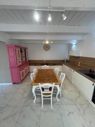 - une cuisine avec une table en bois et des chaises blanches dans l'établissement Les maisons de Lina, à Les Mées