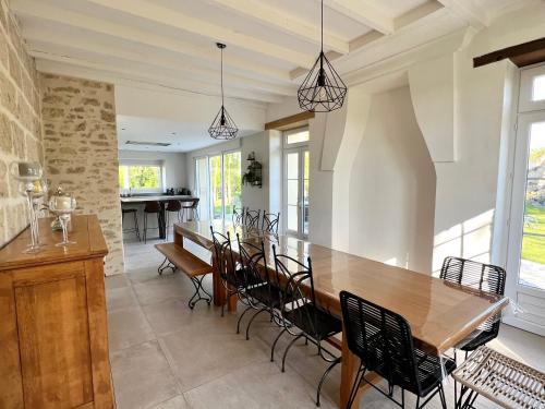 une salle à manger avec une table et des chaises en bois dans l'établissement Le Havre des Perrières - Gîte avec spa, 15 personnes, 5 chambres, à Vaudelnay