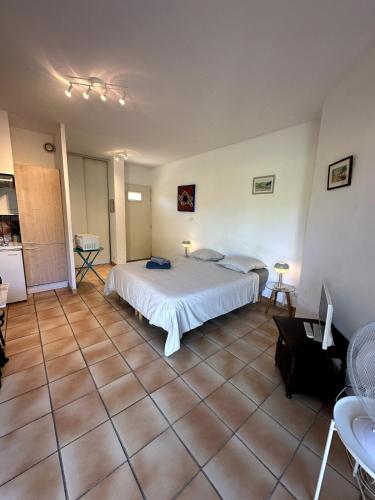- une chambre avec un lit blanc et du carrelage dans l'établissement Le Cap, à Cassis