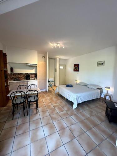 une chambre avec un lit et des chaises et une cuisine dans l'établissement Le Cap, à Cassis