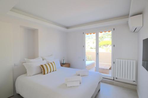 a white bedroom with a large white bed and a window at Luxury 2bedrms with SeaView CityCenter&Parking #4 in Roquebrune-Cap-Martin