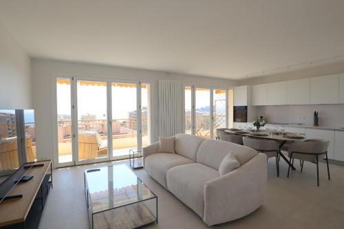 un salon avec un canapé et une table et une cuisine dans l'établissement Luxury 2bedrms with SeaView CityCenter&Parking #4, à Roquebrune-Cap-Martin