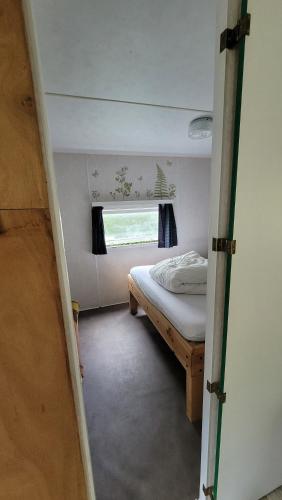 a small room with a bed and a window at Mobile home toutes saisons in Beauzac