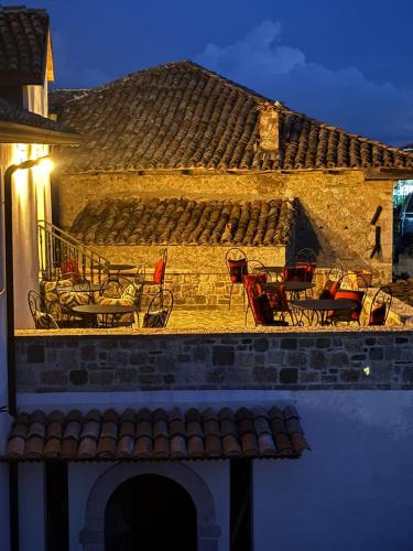 a building with tables and chairs on a balcony at Kruja Albergo Diffuso , Inside Kruja Castle in Krujë