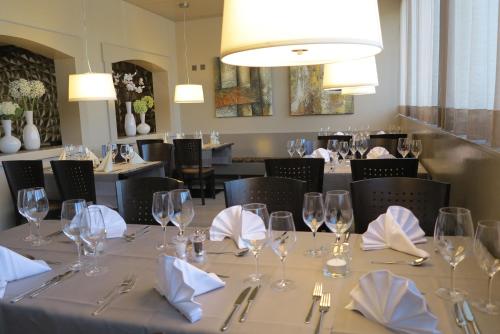 a dining room with a table with glasses and napkins at Hotel Bahnhof in Uzwil